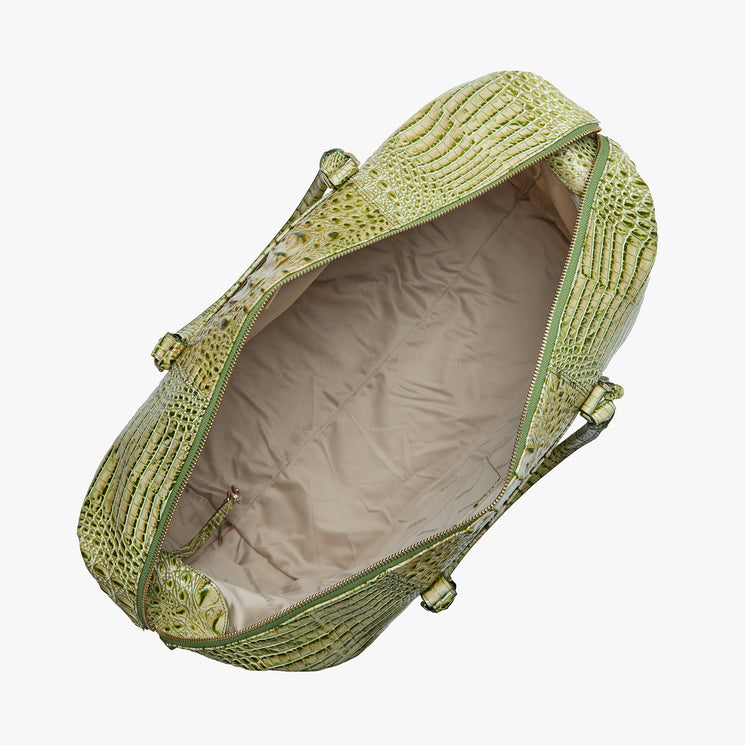 Brahmin green textured duffel bag with structured silhouette, gold-tone hardware, beige fabric interior, interior side zipper pocket, and dual top handles, shown open from above on a plain white background.