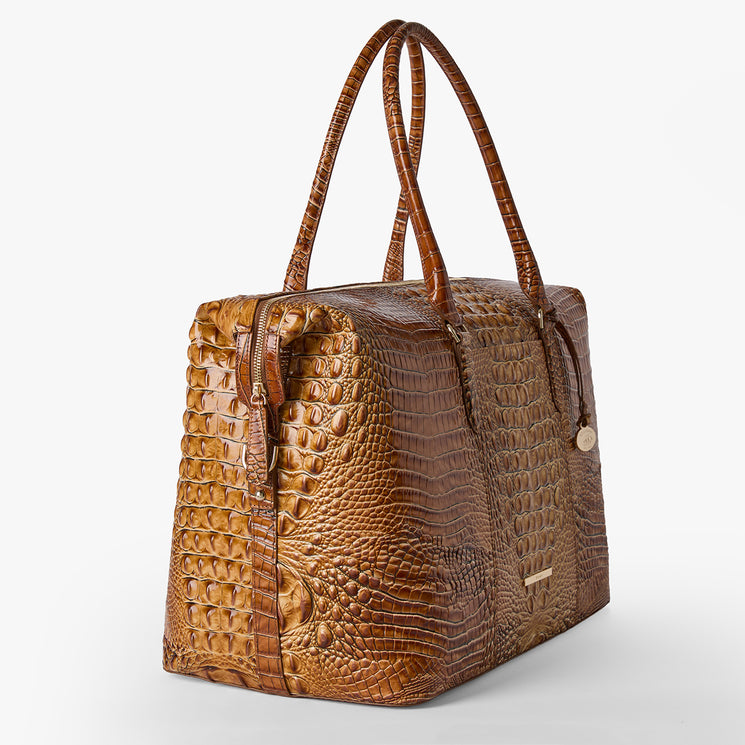 Brahmin handbag in brown textured leather with embossed pattern, structured rectangular silhouette, dual long handles, gold-tone hardware, and clean lines; product shown upright on a plain white background.