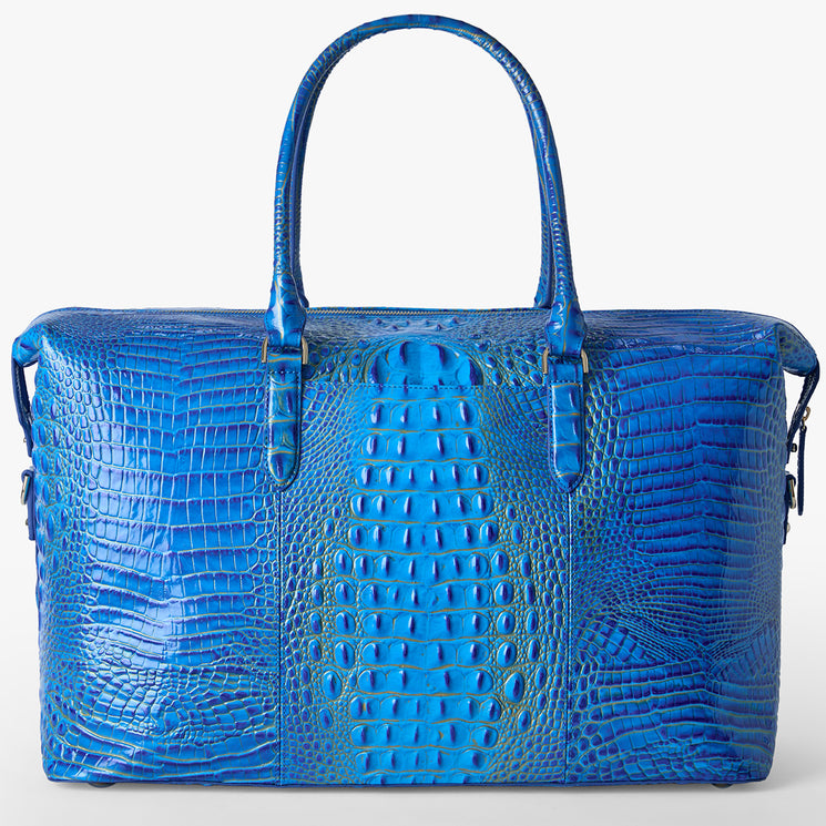 Brahmin bright blue handbag with embossed textured pattern, dual top handles, rectangular silhouette, and silver-tone hardware. Bag displayed upright on a plain light background.