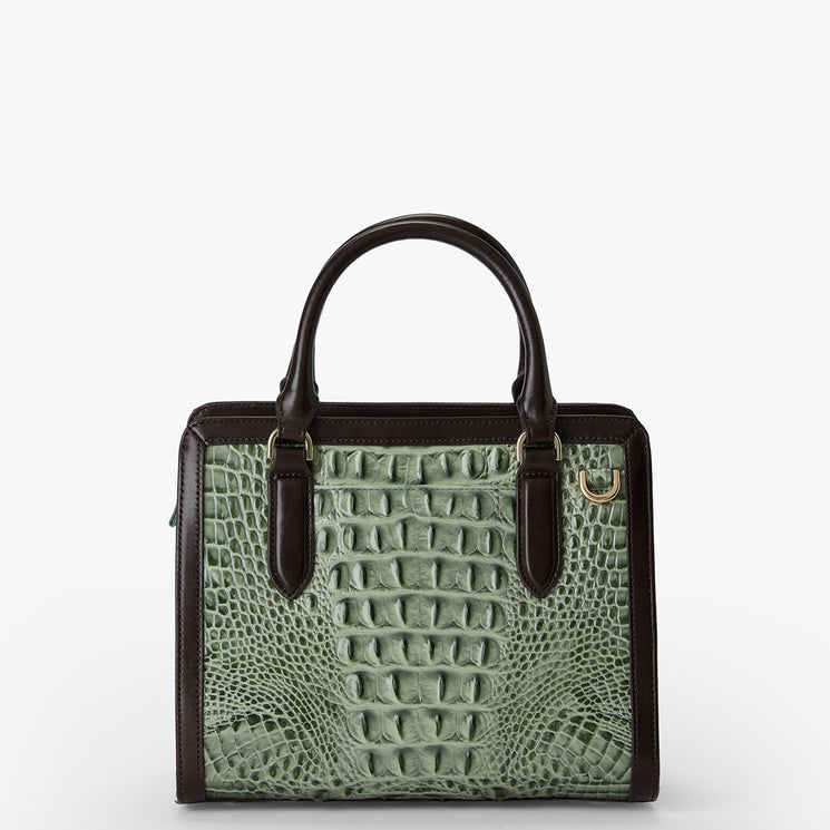 A structured handbag with a light sage green crocodile-embossed front panel and dark brown leather trim, handles, and side panels, shown against a plain white background.