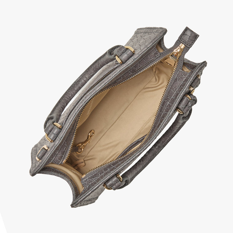 Brahmin gray textured satchel, top view, features two handles, gold zipper closure, beige interior lining with a small gold clasp. Empty handbag displayed on white background; structured silhouette shown open.