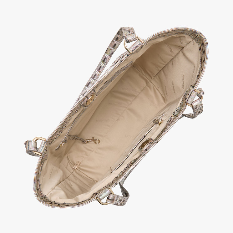 Top view of an open Brahmin satchel in beige with textured, crocodile-inspired exterior, gold-tone hardware, two top handles, beige fabric lining, interior zip pocket—all visible against a white background.