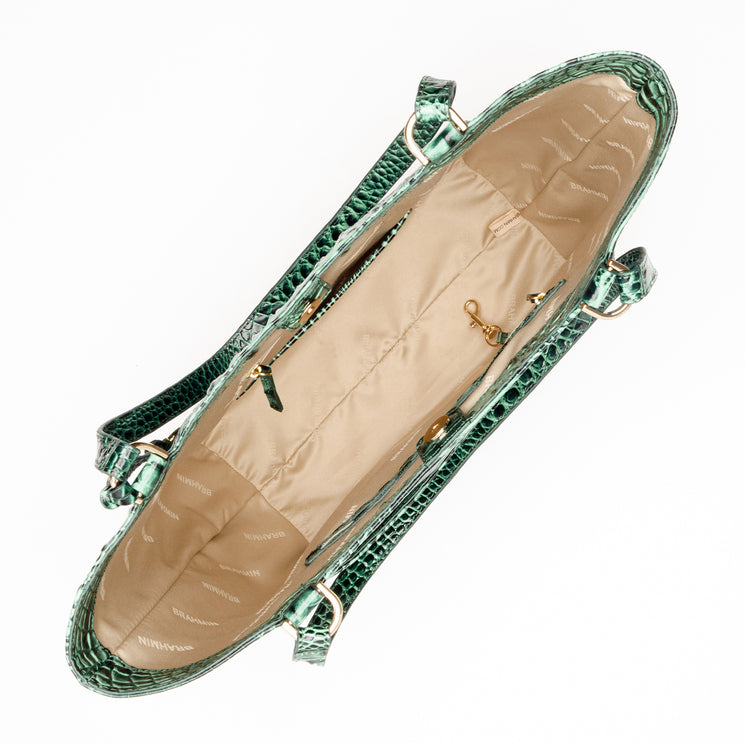Open interior of a forest green croc-embossed Brahmin Aliza tote featuring a beige fabric lining and gold-tone key clip.