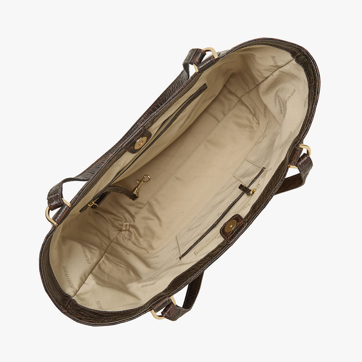 Top view of open Brahmin brown leather tote bag with beige fabric lining, gold-tone hardware, dual handles, interior pockets, key leash, and spacious main compartment. Structured silhouette shown from above.