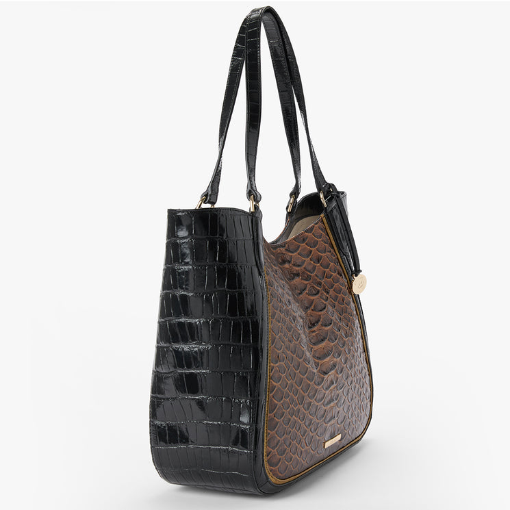 A structured shoulder tote bag featuring a glossy black crocodile-embossed side panel and handles, contrasted with a brown textured reptile-embossed front panel, shown on a light gray background.