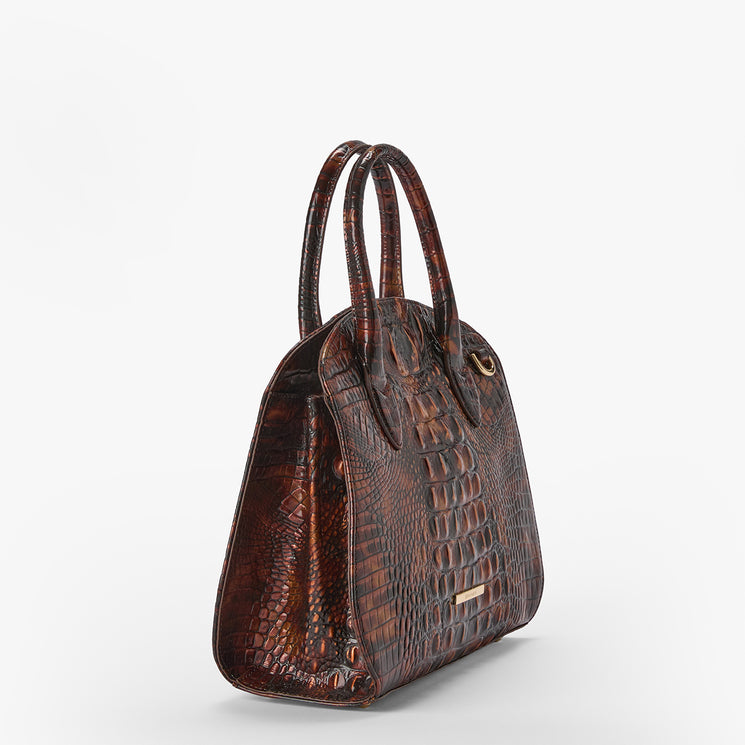 A brown crocodile-embossed leather handbag with dual top handles and a small gold-tone metal plaque on the front, shown against a plain white background.