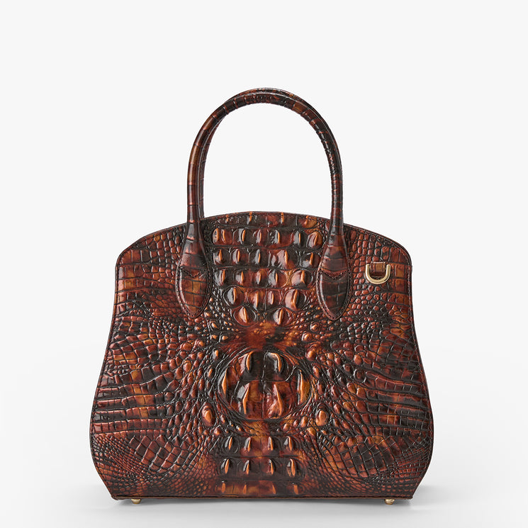 A structured brown crocodile-embossed handbag with dual top handles and a small gold-tone ring detail on the right side, shown against a plain light gray background.