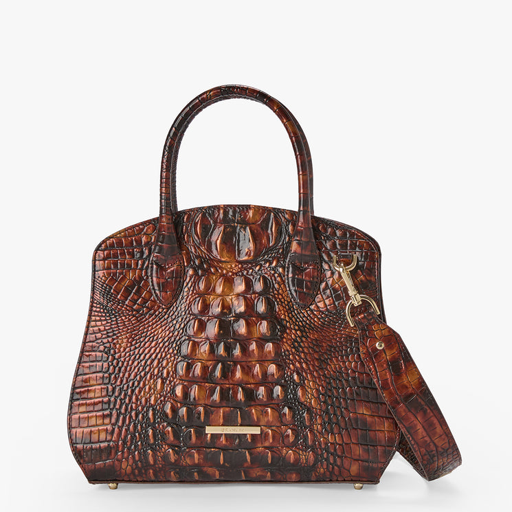 A brown crocodile-embossed leather handbag with dual top handles and a detachable shoulder strap, shown against a plain light gray background.