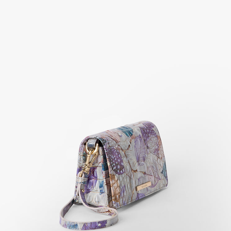 Brahmin crossbody bag with pastel butterfly pattern, gold-tone hardware, and adjustable matching strap; structured silhouette shown on a white background with zipper closure and exterior details visible.