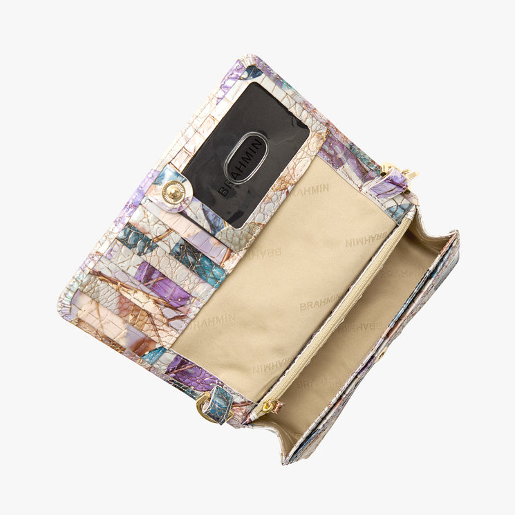 BRAHMIN pastel wallet with embossed crocodile pattern, open to show a transparent ID slot, beige compartments, interior zip pocket, and “BRAHMIN” logo print. Structured silhouette and elegant design in view.
