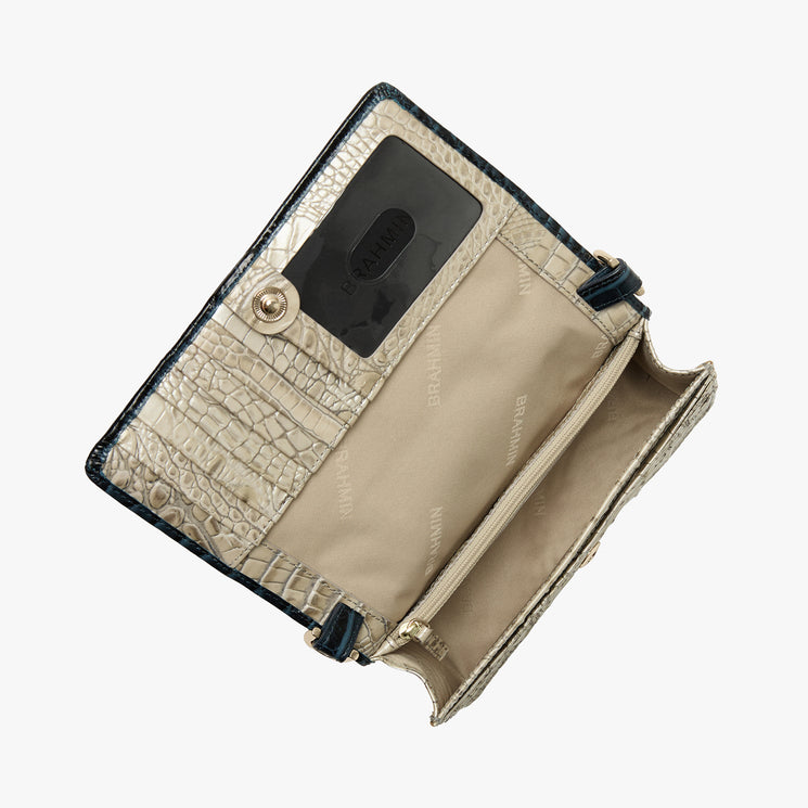 Brahmin beige wallet with embossed texture, snap closure, clear ID window, multiple card slots, and zip compartment. Wallet is open to display organized interior; shown on a white background.