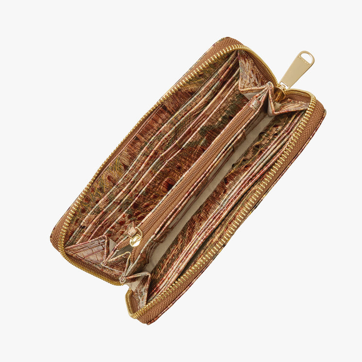 A zip-around wallet with a textured crocodile skin pattern in brown, beige, and green, featuring a gold Brahmin plaque and zipper pull. Suri Open View.
