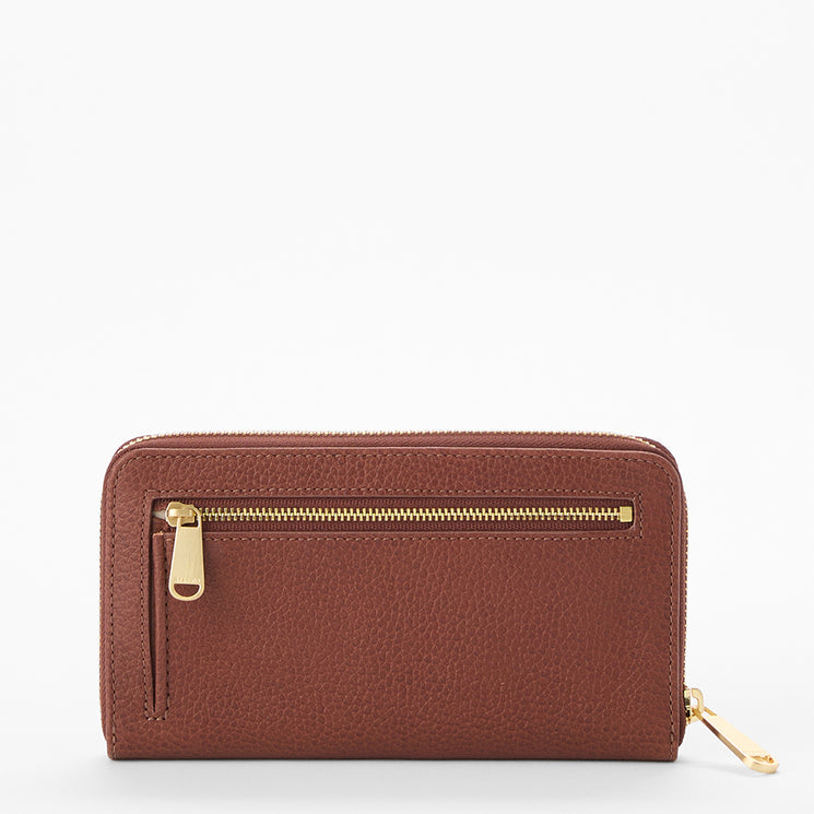 Brahmin brown leather wallet with a gold-tone zipper pocket on the front and a matching gold zipper pull on the side, shown against a plain white background. Structured silhouette, exterior hardware detail visible.