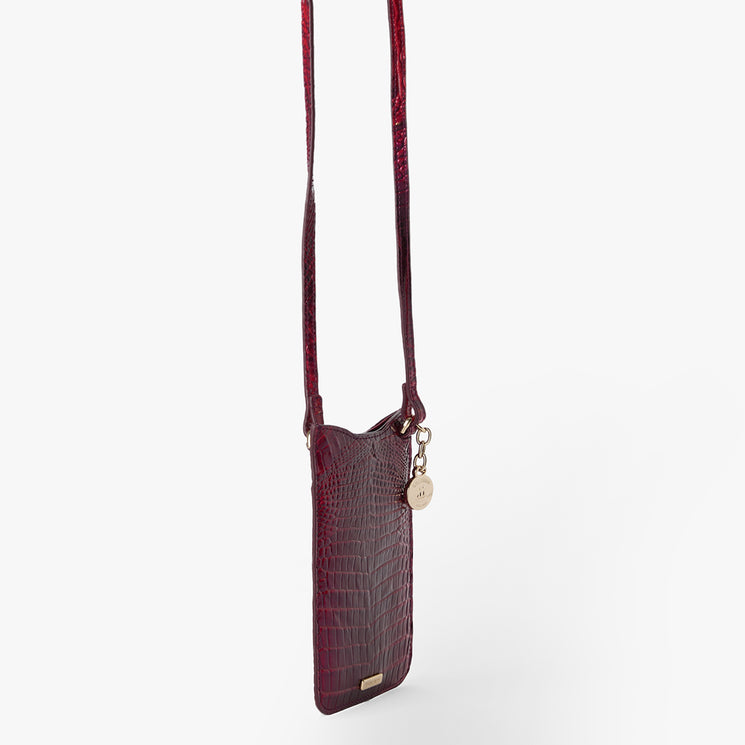 BRAHMIN Eris small crossbody bag in burgundy with embossed crocodile texture, gold-tone charm, slip top opening, and a long adjustable strap, displayed upright against a plain white background.