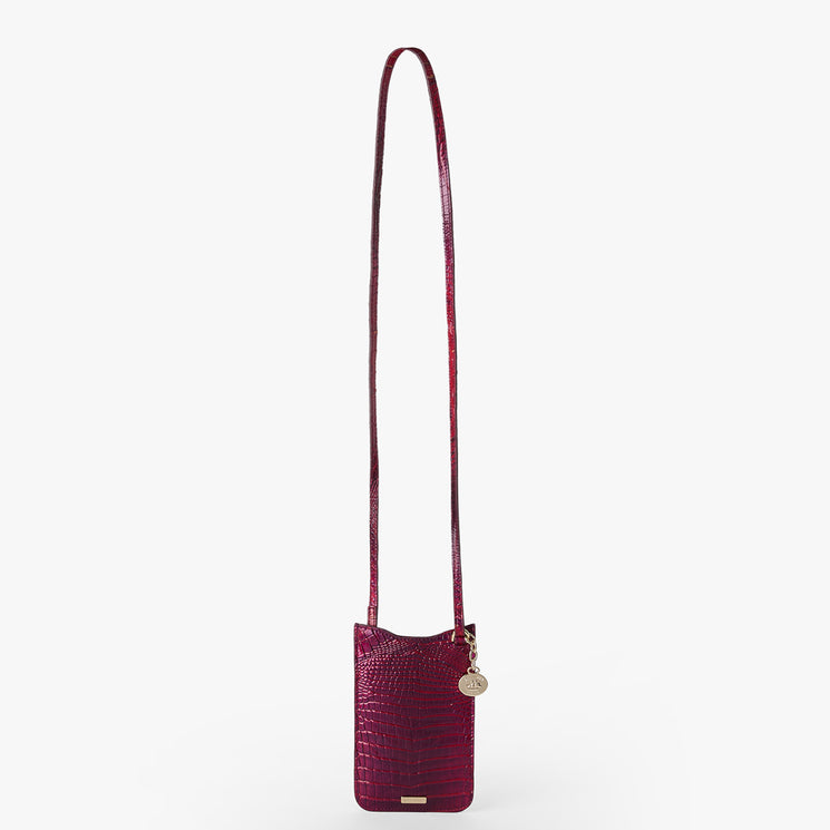 BRAHMIN Eris small crossbody bag in deep red with embossed texture, rectangular silhouette, slip top closure, gold-tone hardware and charm, phone pouch detail, adjustable strap, metal logo plate at base.